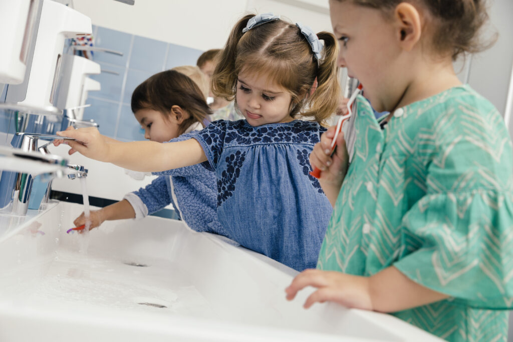 Children brushing their teeth in bathroom of a kindergarten